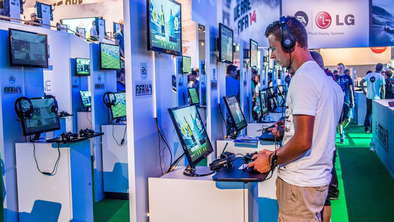 Visitors at FIFA 14 gaming stations at Gamescom 2013 in Cologne