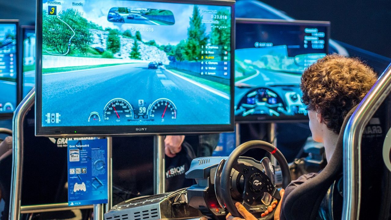 Visitors at Gran Turismo 6 demo seats on the PlayStation stand at Gamescom 2013