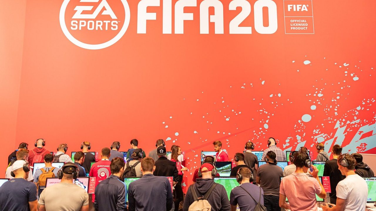 Visitors playing EA Sports FIFA 20 at gaming stations on the EA Sports stand at Gamescom 2019
